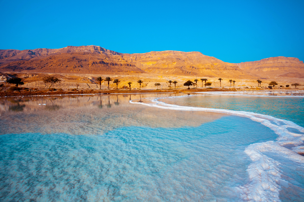 Discover the Dead Sea in Jordan, famous for its extremely high salt content, mineral-rich mud, and unique experience of floating effortlessly in its buoyant waters, surrounded by stunning desert landscapes