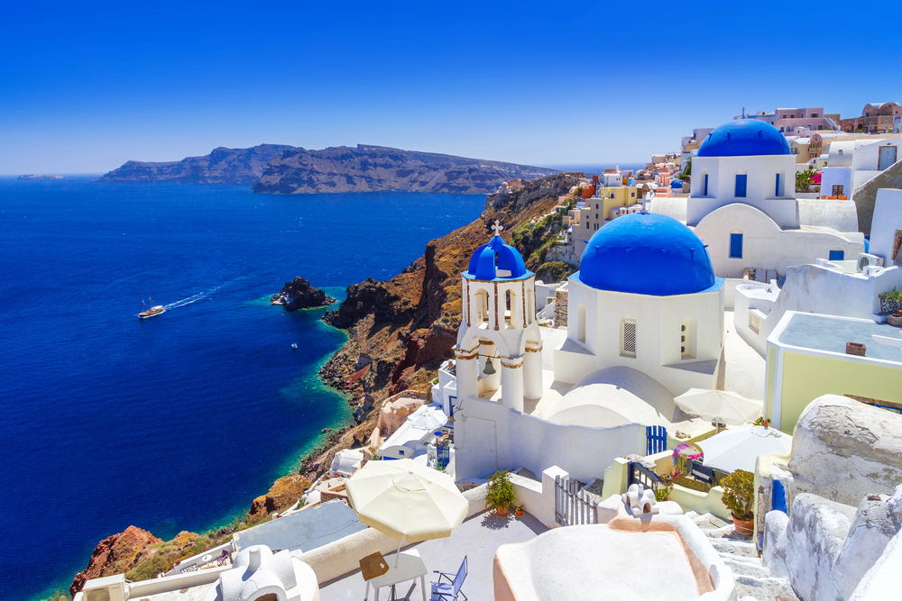 Explore Santorini, a picturesque island in Greece, known for its stunning sunsets, whitewashed buildings with blue domes, volcanic beaches, and vibrant local culture