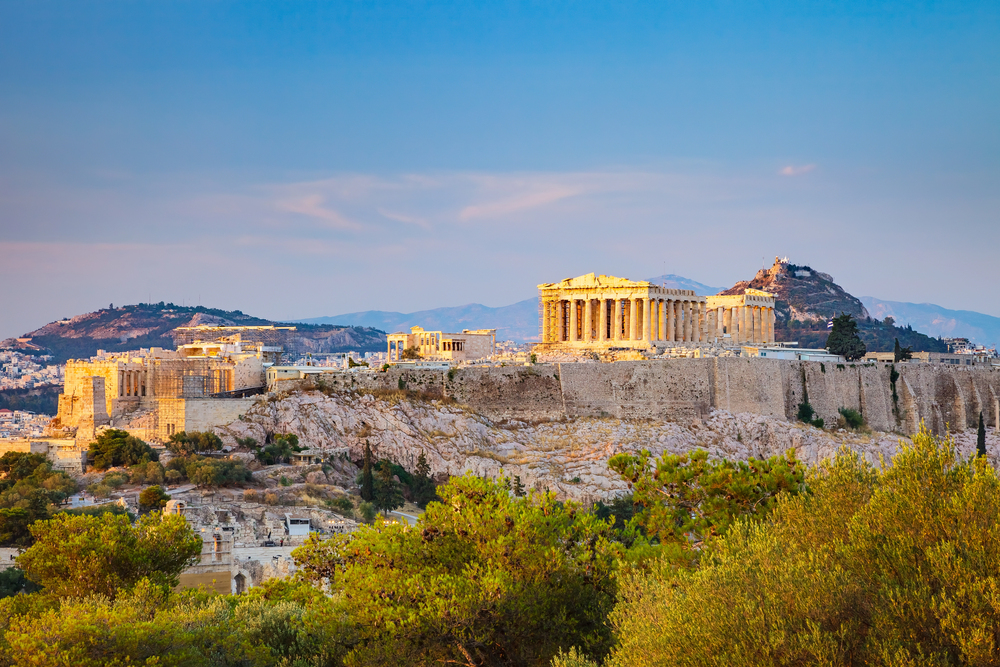 The Parthenon temple on the Acropolis hill with blue sky and views over Athens, Greece