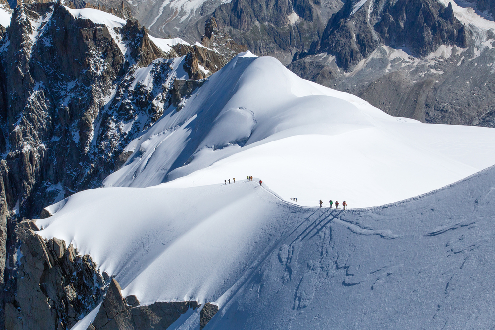Snow-covered mountains of Mont Blanc towering above the town of Chamonix with clear skies and Alpine rooftops, France