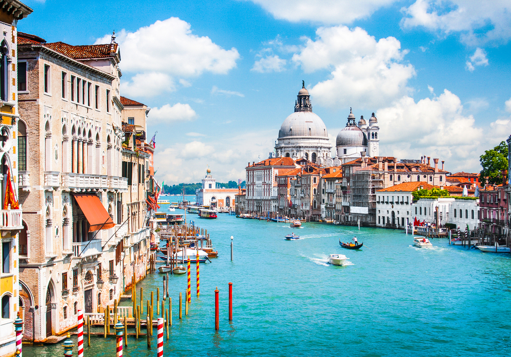 Gondola gliding under a bridge with St. Mark's Basilica and Doge's Palace in the background, Venice, Italy