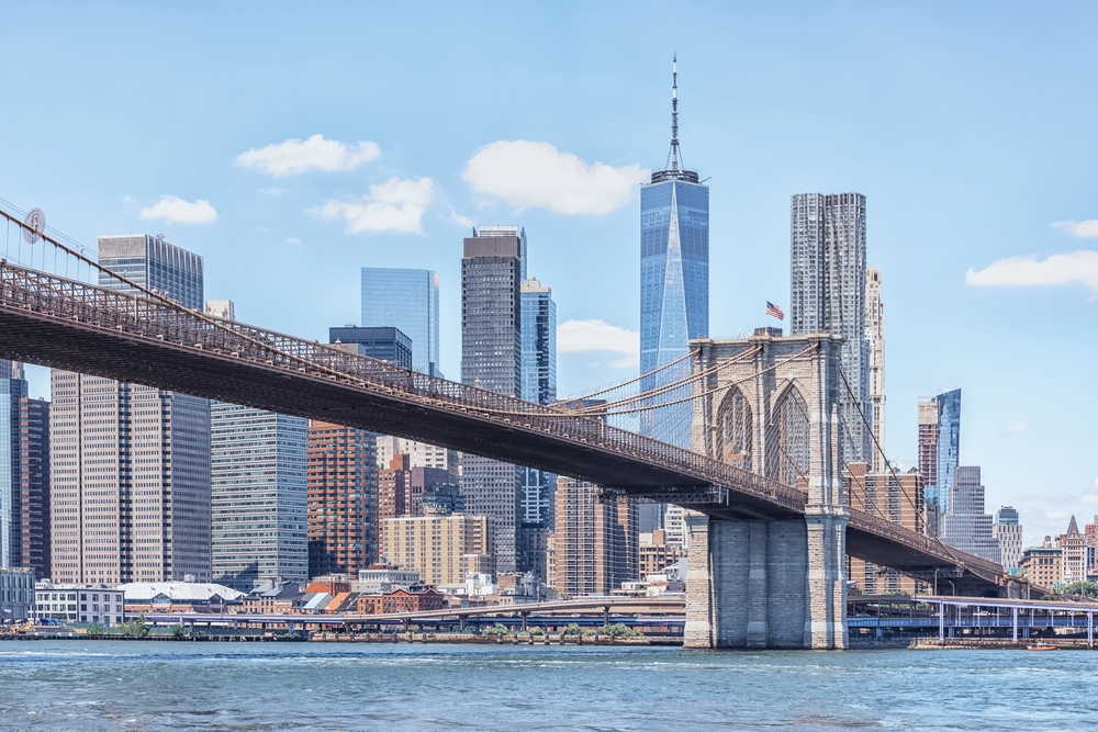 Cruise boat on the Hudson River passing the Statue of Liberty with New York City skyline in the background, USA