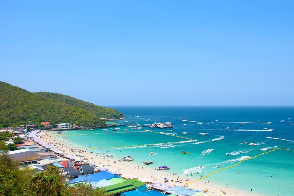 White sand beach with turquoise water and longtail boats on Koh Larn near Pattaya, Thailand
