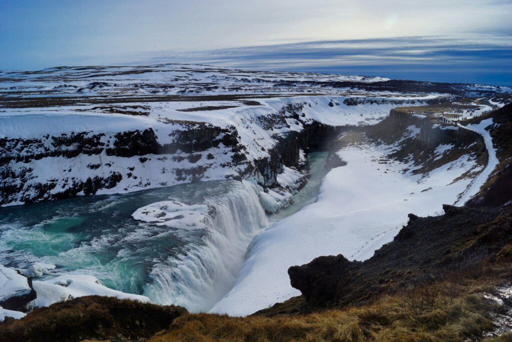 Gullfoss waterfall thundering into a canyon, with bright skies overhead, part of Iceland’s Golden Circle tour